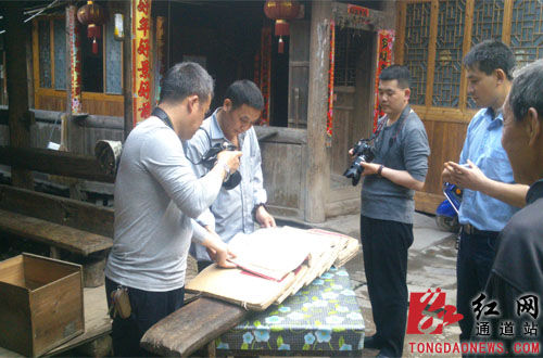 圖為研究人員在翻閱《吳氏族譜》