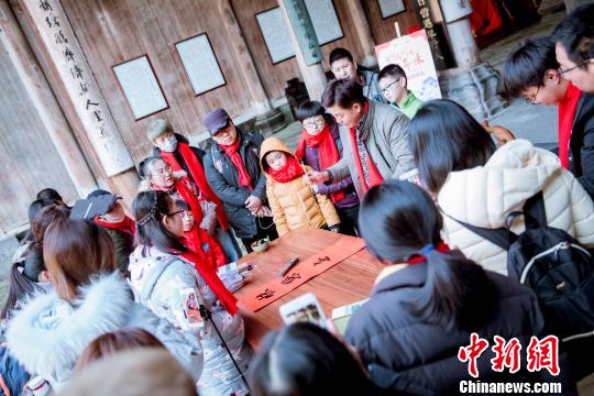 游客在敬愛堂內(nèi)寫春聯(lián) 徽黃旅游集團(tuán)供圖 攝