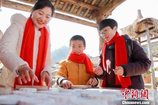 游客體驗(yàn)特色年俗打食桃 查亞棟 攝